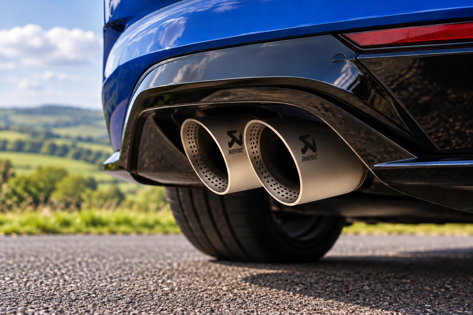 Close-up illustration of optional Akrapovič exhaust outlets on a blue Golf R.